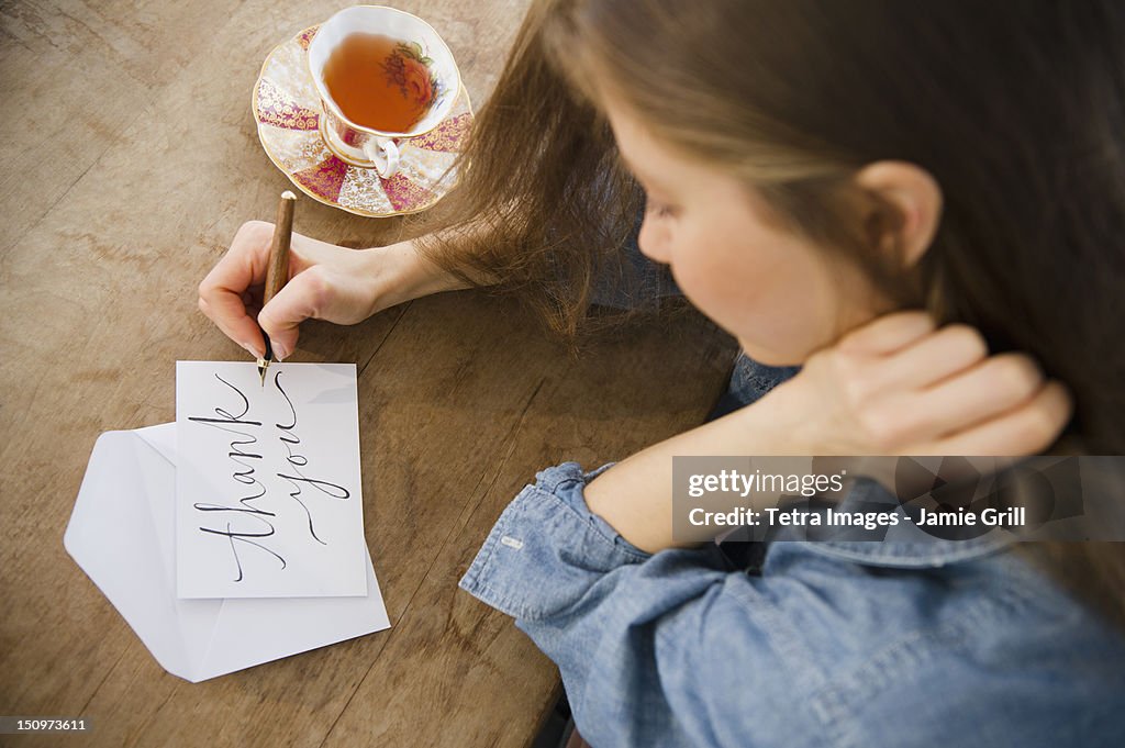 USA, New Jersey, Jersey City, Woman writing greeting card