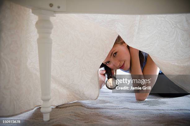 usa, new jersey, jersey city, woman with flashlight looking under bed - mirar abajo fotografías e imágenes de stock