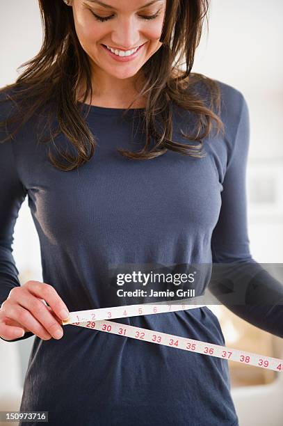 usa, new jersey, jersey city, woman measuring herself with measuring tape - woman measuring tape stock pictures, royalty-free photos & images