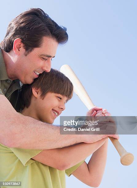 usa, new jersey, jersey city, father teaching son (10-11 years) how to play baseball - 50 54 years stockfoto's en -beelden