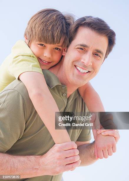 usa, new jersey, jersey city, father giving his son (10-11 years) piggyback ride - 50 54 years stockfoto's en -beelden