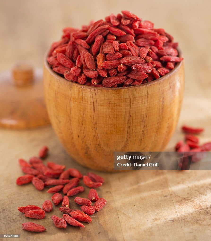 Close up of goji berries in wooden bowl, studio shot