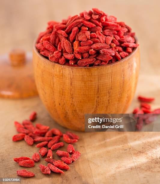 close up of goji berries in wooden bowl, studio shot - goji berry stock pictures, royalty-free photos & images