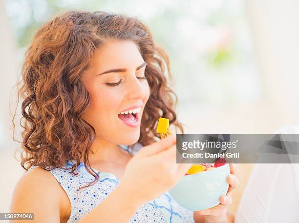 usa, new jersey, jersey city, portrait of woman eating fruit salad - mouth open eating stock pictures, royalty-free photos & images