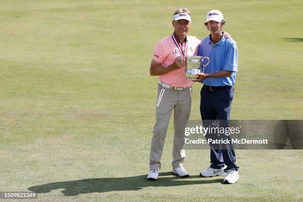 Bernhard Langer of Germany and caddie Terry Holt poses with the Francis D. Ouimet Memorial Trophy after winning the U.S. Senior Open Championship at...