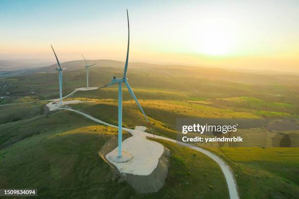 wind turbines at sunset, renewable energy source - wind farms stockfoto's en -beelden