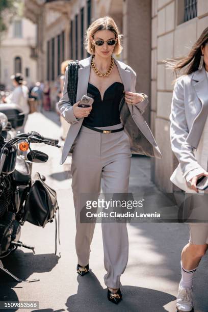 Guest, wearing a black corsage, black Balenciaga shoes and grey tailleur, is seen outside Giorgio Armani show during the Milan Fashion Week -...