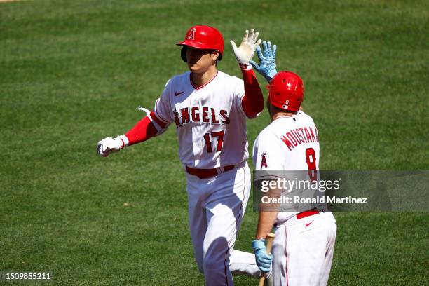 Shohei Ohtani of the Los Angeles Angels celebrates a home run with Mike Moustakas against the Arizona Diamondbacks in the eighth inning at Angel...