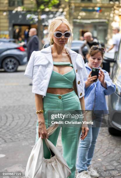 Christine Quinn wears green cropped top, pants, white jacket, bag, sunglasses outside Patou on July 02, 2023 in Paris, France.