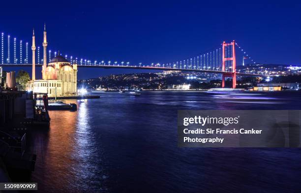 iconic "bosphorus bridge" illuminated at dusk with ortakoy mosque on the left hand side in besiktas, istanbul, tukey - istanbul sunset stock pictures, royalty-free photos & images