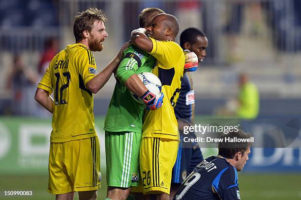 Eddie Gaven, Matt Lampson and Julius James of the Columbus Crew celebrate a 2-1 in front of a deject Amobi Okugo and Antoine Hoppenot of the...