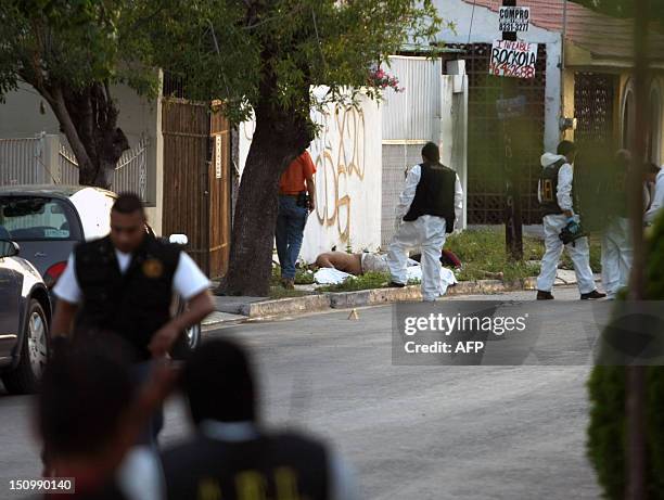 Members of the state police and forensic personnel work in a crime scene where three men and a woman were killed by gunmen in Monterrey, Mexico on...