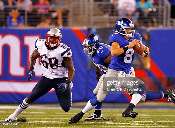 Quarterback David Carr of the New York Giants looks to pass as he is pursued by Justin Francis of the New England Patriots during an NFL pre-season...