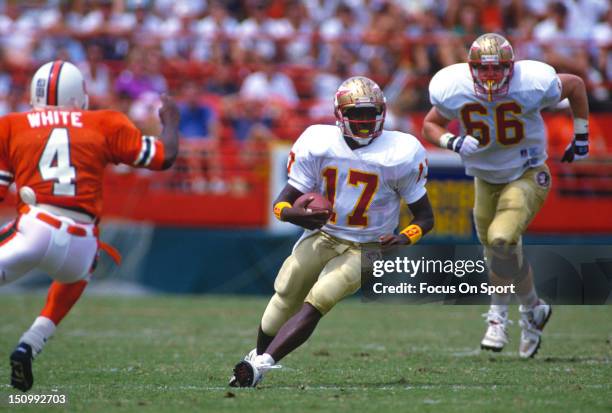 Charlie Ward of the Florida State Seminoles runs with the ball against the University of Miami during an NCAA football game at the Orange Bowl...