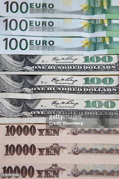 One-hundred euro, top, U.S. One-hundred dollar, center, and ten-thousand yen banknotes are arranged for a photograph in Soka City, Saitama...