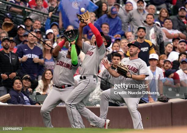 Amed Rosario of the Cleveland Guardians collides with Jose Ramirez of the Cleveland Guardians as he catches a fly ball during the first inning...
