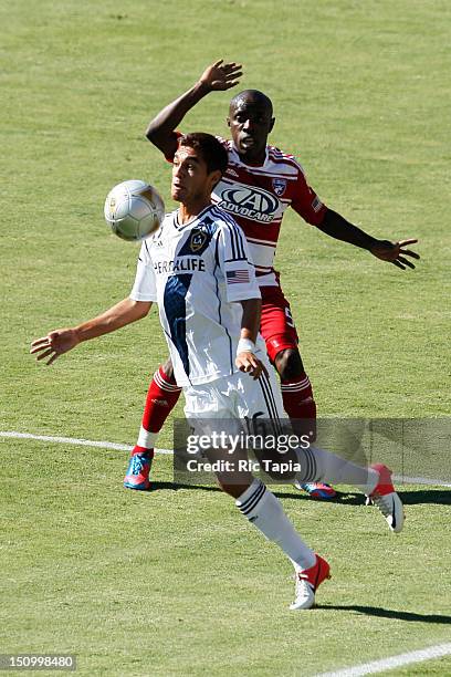 Hector Jimenez of Los Angeles Galaxy plays the ball while being guarded by Jair Benitez of FC Dallas during the MLS match at The Home Depot Center on...