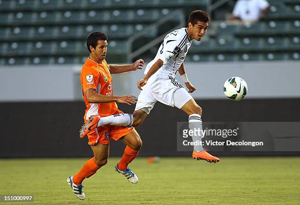 Hector Jimenez of the Los Angeles Galaxy plays the ball from Justin Fojo of the Puerto Rico Islanders during the group stage CONCACAF Champions...