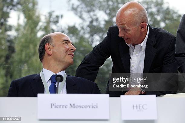 Pierre Moscovici, France's finance minister, left, speaks to Pascal Lamy, director general of the World Trade Organisation, before a plenary session...
