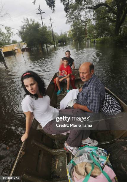 Joshua Barbot rescues family members Christie, Ethan and Larry Trumbaturi from their flooded home in his boat on August 30, 2012 in Slidell,...