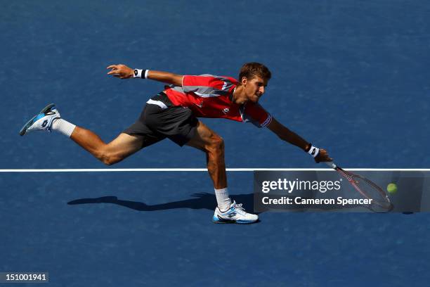Martin Klizan of Slovakia returns a shot against Jo-Wilfried Tsonga of France during their men's singles second round match on Day Four of the 2012...