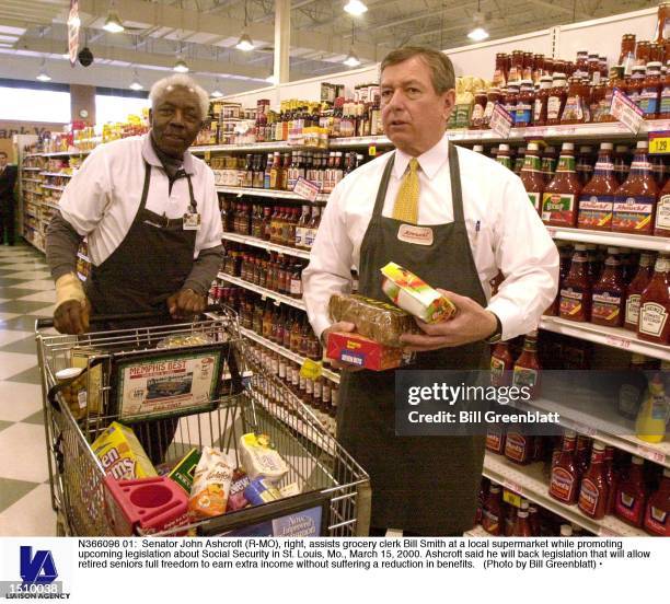 Senator John Ashcroft , right, assists grocery clerk Bill Smith at a local supermarket while promoting upcoming legislation about Social Security in...