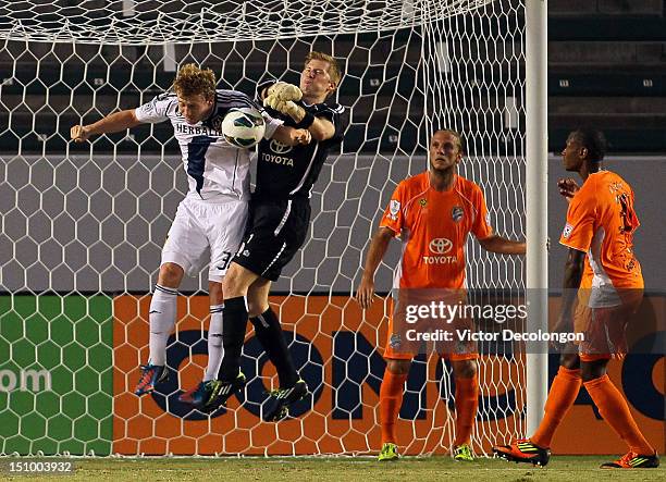 Goalkeeper Richard Martin of the Puerto Rico Islanders makes a save as Jack McBean of the Los Angeles Galaxy tries for the header during the group...