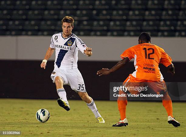 Bryan Gaul of the Los Angeles Galaxy steps over the ball on the attack against Eddie Edward of the Puerto Rico Islanders during the group stage...