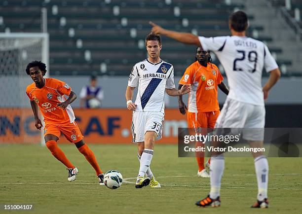 Bryan Gaul of the Los Angeles Galaxy passes the ball as Gregory Richardson of the Puerto Rico Islanders runs into position during their group stage...