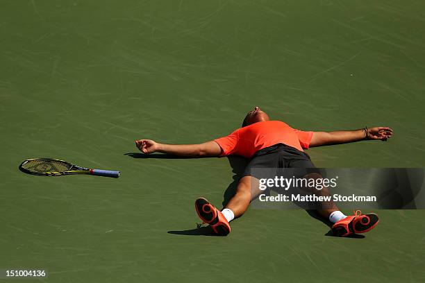 Nicolas Almagro of Spain lies on the court as he celebrates match point after his men's singles second round match against Philipp Petzschner of...