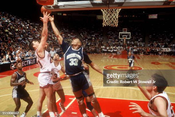 Georgetown's star center Alonzo Mourning battles UConn's Nadav Henefeld for a rebound during a Big East tournament game, Hartford CT, 1990.