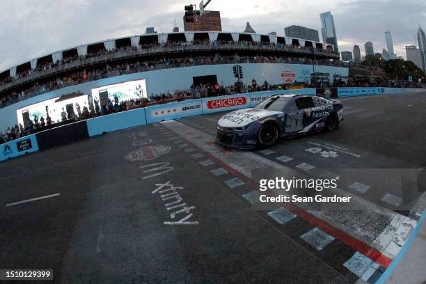 Shane Van Gisbergen, driver of the Enhance Health Chevrolet, crosses the finish line to win the NASCAR Cup Series Grant Park 220 at the Chicago...