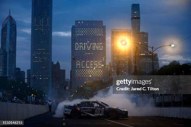 Shane Van Gisbergen, driver of the Enhance Health Chevrolet, celebrates with a burnout after winning the NASCAR Cup Series Grant Park 220 at the...