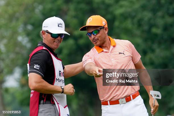 Rickie Fowler of the United States and his caddie, Ricky Romano, celebrate on the 18th green after defeating Adam Hadwin of Canada and Collin...