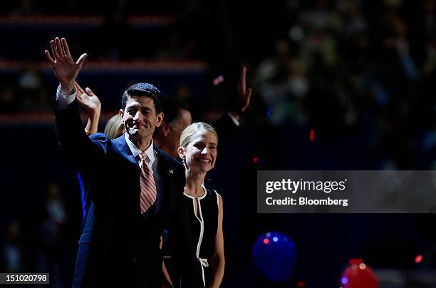 Representative Paul Ryan, Republican vice presidential candidate, left, waves while on stage with wife Janna Ryan at the Republican National...