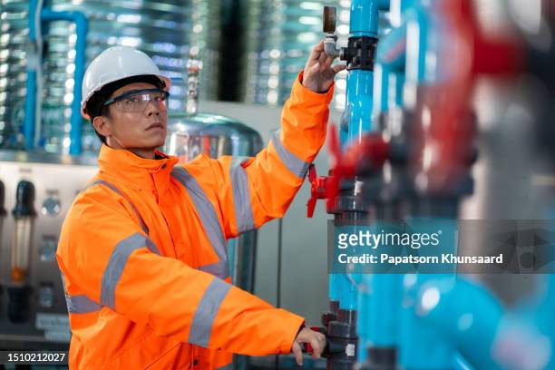 asian technician engineer maintenance  drinking water pipe and pressure tank . - sewage stockfoto's en -beelden