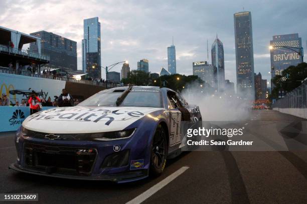 Shane Van Gisbergen, driver of the Enhance Health Chevrolet, celebrates with a burnout after winning the NASCAR Cup Series Grant Park 220 at the...
