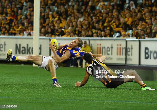Adam Selwood of the Eagles is tackled by Paul Puopolo of the Hawks during the round 23 AFL match between the Hawthorn Hawks and the West Coast Eagles...