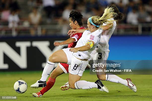 Cari Roccaro and Julie Johnston of the USA attempt to tackle Kim Un Hwa of Korea DPR during the FIFA U-20 Women's World Cup Quarter-Final match...