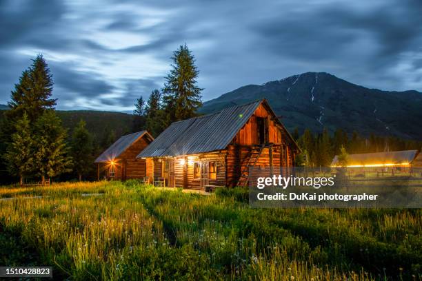 wood house at night  in kanas hemu village , xinjiang province, china - howse peak stock pictures, royalty-free photos & images