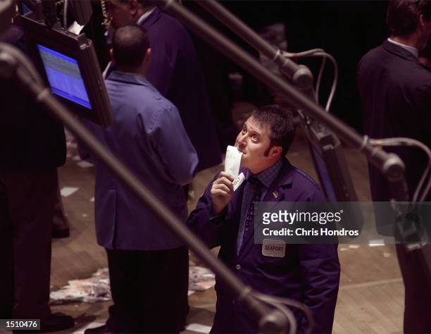 Trader looks at a monitor on the floor of the New York Stock Exchange in New York April 14, 2000. Stocks plummeted Friday in a broad sell-off as the...