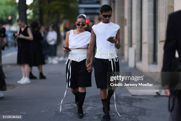 Guests are seen wearing white Sandro tank tops, black sunnies, white and black colored cotton shorts and black tights with black sneakers outside...