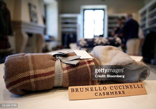 Brunello Cucinelli cashmere sign sits in front of woven garments displayed for sale at the company's store in Solomeo, near Perugia, Italy, on...