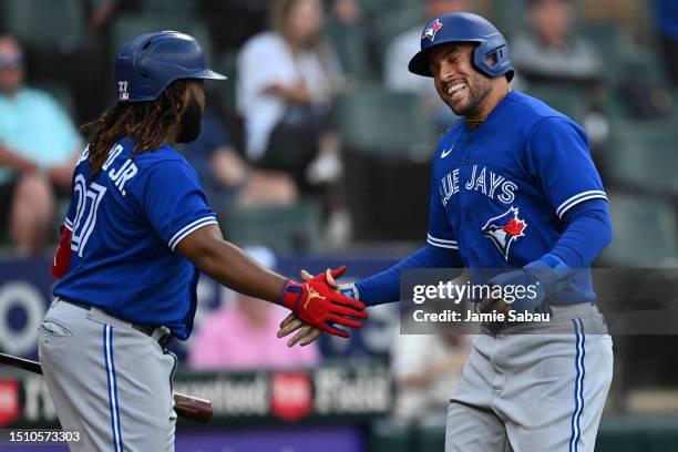 George Springer of the Toronto Blue Jays celebrates scoring a run with Vladimir Guerrero Jr. #27 in the 11th inning of game one of a double-header...