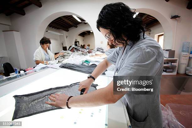 Employees check garments for defects during the quality control process at the Brunello Cucinelli SpA production facility in Solomeo, near Perugia,...