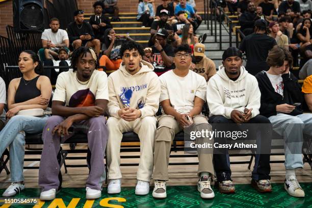 Zaire Wade and friends watch games court side during the Drew League at King Drew Magnet High School on July 02, 2023 in Los Angeles, California.