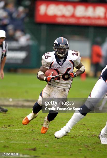 Clinton Portis of the Denver Broncos carries the ball against the Oakland Raiders during an NFL football game on November 30, 2003 at the Oakland...