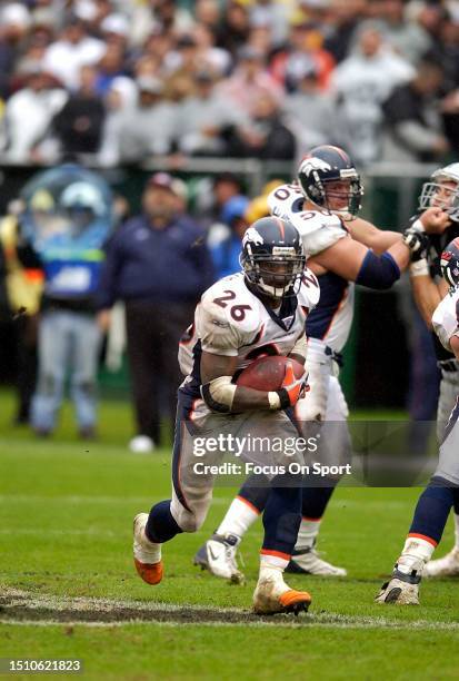 Clinton Portis of the Denver Broncos carries the ball against the Oakland Raiders during an NFL football game on November 30, 2003 at the Oakland...