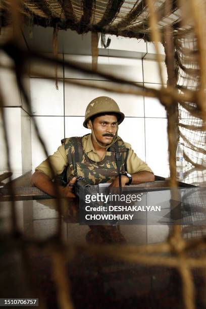An Indian paramilitary soldier stands guard at the exit of Netaji Subhash Chandra Bose International Airport in Kolkata, 11 August 2006. The US...