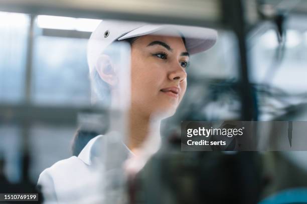 portrait of young beautiful engineer woman working in factory building. - selective focus bildbanksfoton och bilder